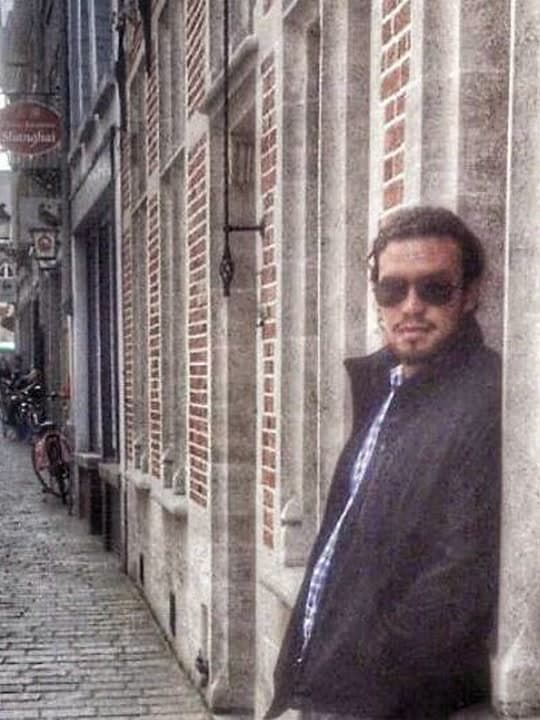 Leaning against a stone column in the old town of Bruges
